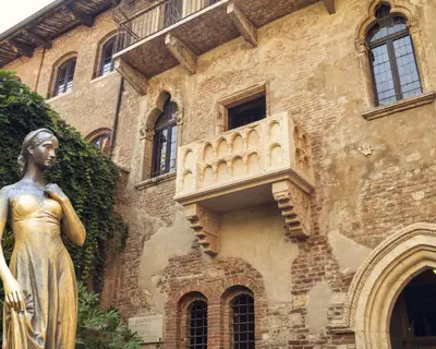Bronze statue of Juliet and balcony by Juliet house, Verona, Italy.