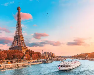 The main attraction of Paris and all of Europe is the Eiffel tower in the rays of the setting sun on the bank of Seine river with cruise tourist ships