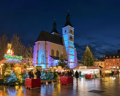 Regensburg, Germany. The city's main Christmas market on the Neupfarrplatz (New Parish Square) around the Neupfarrkirche (New Parish Church) in dusk.