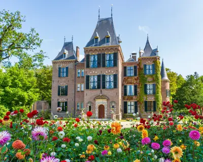 The front view of a beautiful castle with the colorful dahlias in the foreground in a park in Lisse, the Netherlands