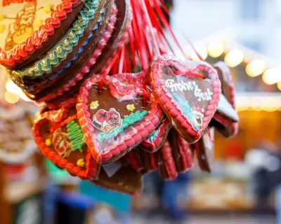 Gingerbread Hearts at German Christmas Market. Nuremberg, Munich, Berlin, Hamburg xmas market in Germany. On traditional ginger bread cookies written Happy Holiday called Lebkuchenherz in German.