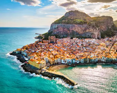 Drone view from above at the old town of Cefalu at sunset, medieval village of Sicily island, Province of Palermo, Italy. Europe. Cathedral of Cefalu
