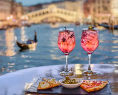 pink aperitif and appetizers with the Grand Canal in Venice in the background