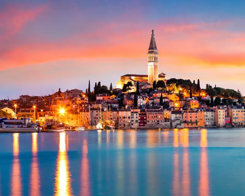 Fantastic spring sunset of Rovinj town, Croatian fishing port on the west coast of the Istrian peninsula. Colorful evening seascape of Adriatic Sea. Traveling concept background.